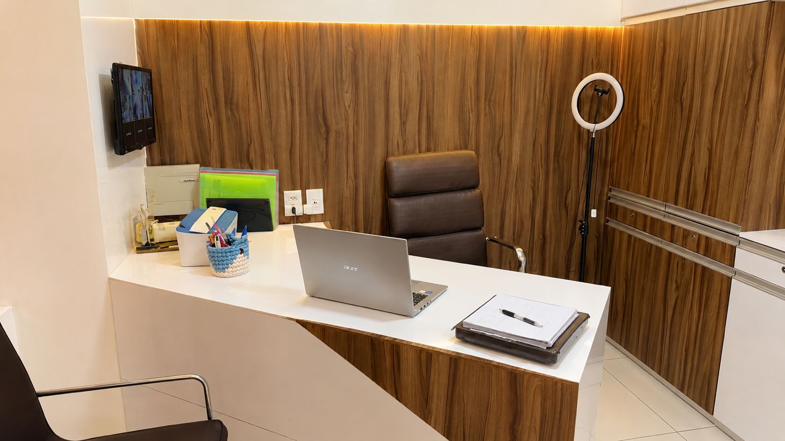 Escritório com mesa de atendimento e parede em madeira